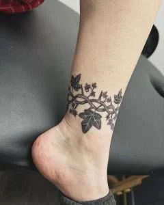 Delicate floral vine wrapping the ankle in fine line, tattooed at Nu Nebula Tattoo