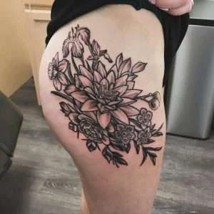 Botanical thigh piece in fine-line black and grey, tattooed at Nu Nebula Tattoo