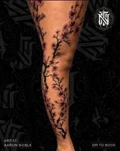Cherry blossom branch running down the leg in fine line, tattooed by Aaron Noble