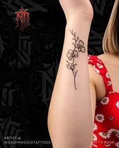 Small floral arm tattoo in fine line, tattooed by Nick DiMaggio