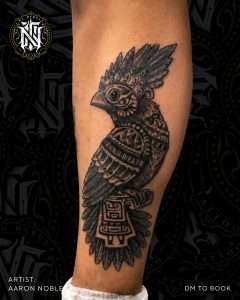 Owl calf tattoo in neo-traditional black and grey, tattooed by Aaron Noble