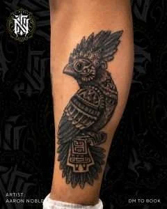 Owl calf tattoo in neo-traditional black and grey, tattooed by Aaron Noble