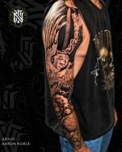 Full arm sleeve in black and grey realism, tattooed by Aaron Noble